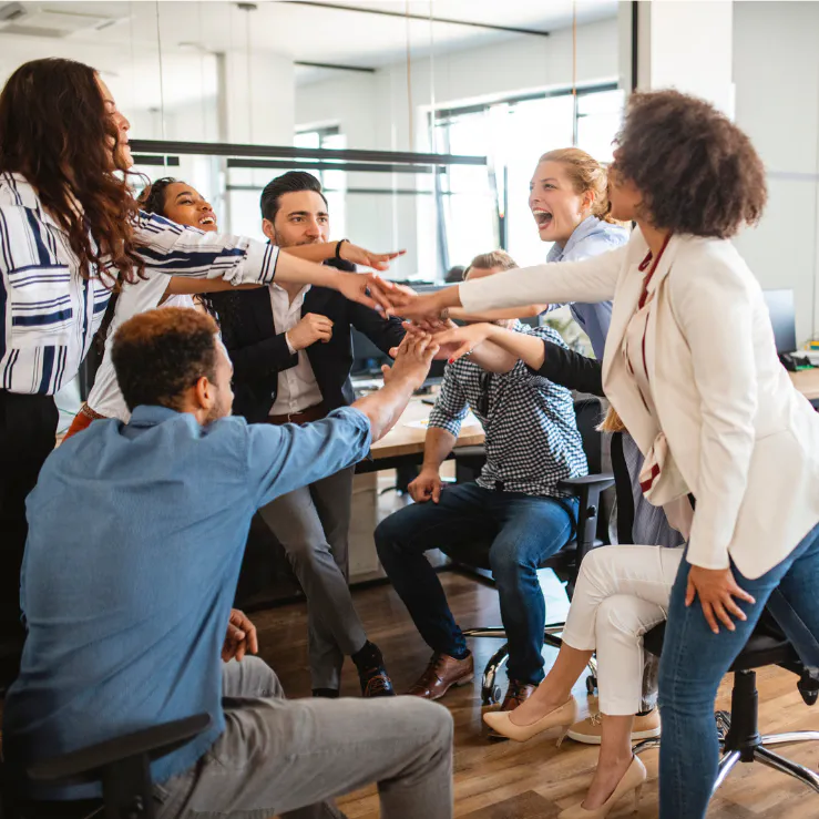 A team meeting with all the team members cheering, a team-building moment after a wellness workshop