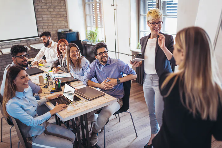 Image of a corporate wellness coach/wellness specialist giving a workshop to a group of employees as part of the company’s employee wellness program.